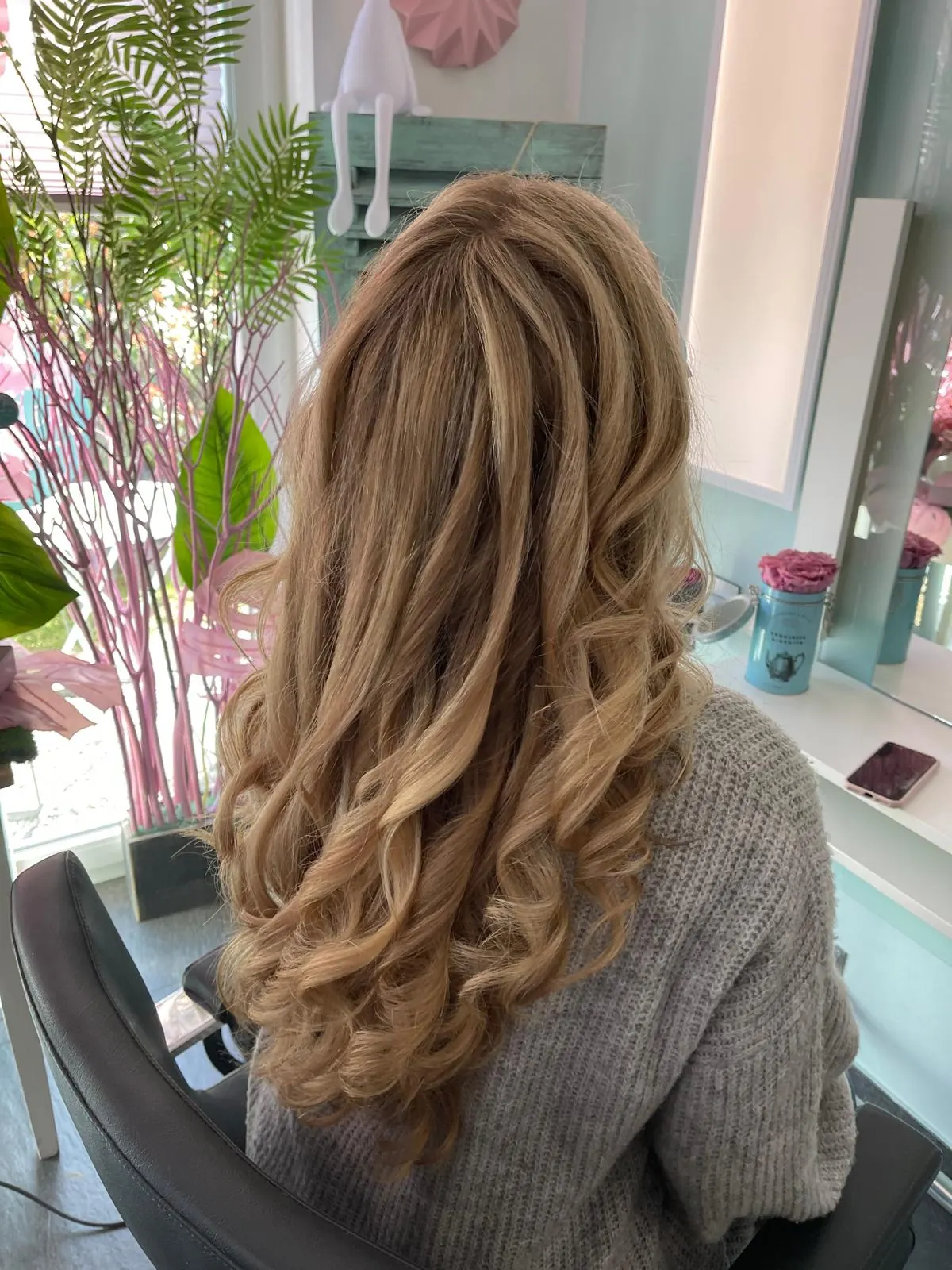 Lange blonde Haare mit voluminösen Locken im Salon