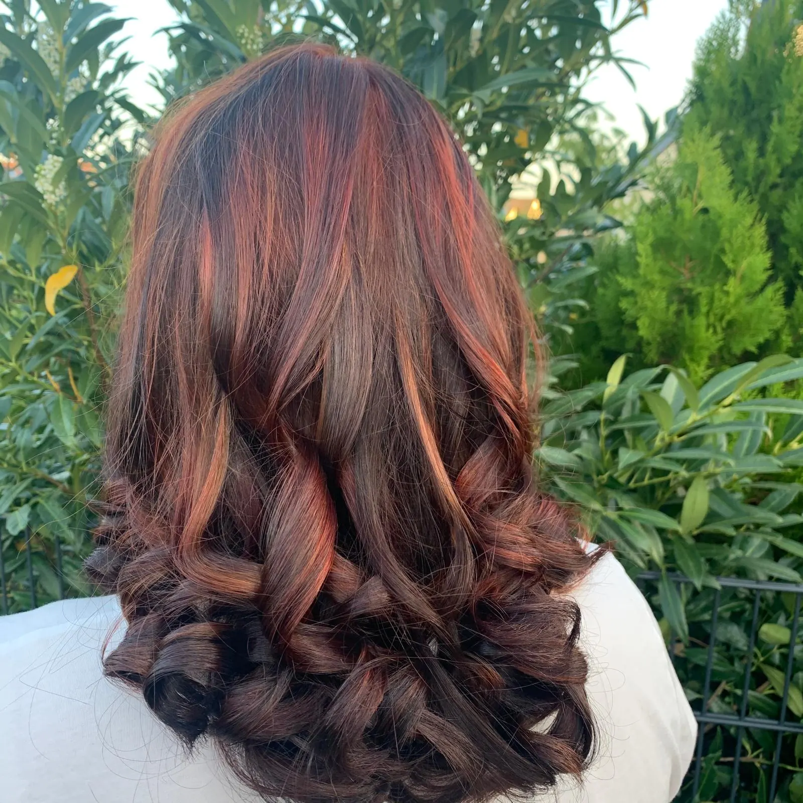 Brünette Haare mit kupfernen Strähnen und Locken